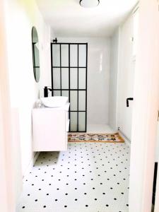 een witte badkamer met een wastafel en een spiegel bij Cottage de Vardes in Neufmarché