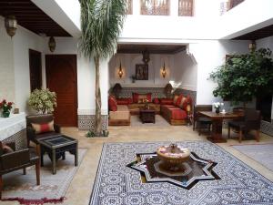 a living room with couches and a palm tree at Riad Viva in Marrakesh