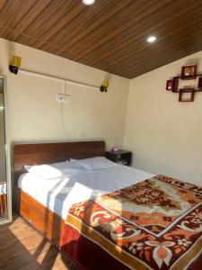 a bedroom with a large bed with a wooden ceiling at Cloudscape Cottage in Shimla