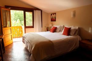 a bedroom with a bed and a large window at Hotel Las Cascadas in La Cumbrecita