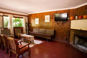 a living room with a couch and a fireplace at Hotel Las Cascadas in La Cumbrecita
