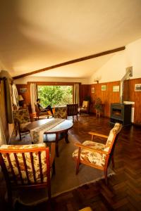 a living room with a table and chairs at Hotel Las Cascadas in La Cumbrecita