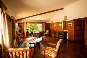 a living room with a table and chairs and a window at Hotel Las Cascadas in La Cumbrecita