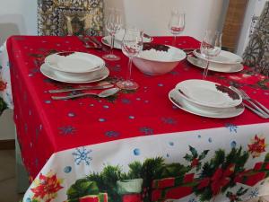 ein roter Weihnachtstisch mit Tellern und Weingläsern in der Unterkunft Casa Friend in Castel di Sangro