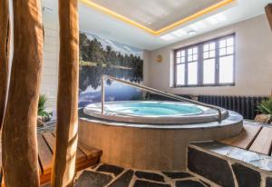 een jacuzzi in een kamer met een groot raam bij REJVÍZ 1 Hotel & Spa in Rejvíz +49 foto's