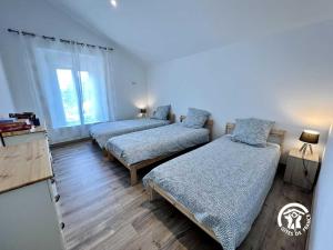 ein Schlafzimmer mit zwei Betten und einem Fenster in der Unterkunft Le gite aux oliviers in Laredorte + 26 Fotos