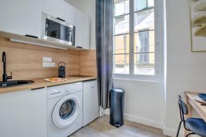 een keuken met een wasmachine en een wastafel bij Wisdom at heart in Périgueux