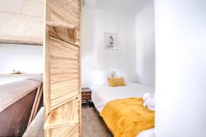 a small bedroom with a bed and a wooden wall at La sagesse in Périgueux