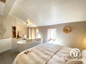 een slaapkamer met een groot bed en een bad bij Casa d'amunt in Prats-de-Mollo-la-Preste