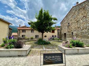 een bord voor een gebouw met een boom bij Casa d'amunt in Prats-de-Mollo-la-Preste