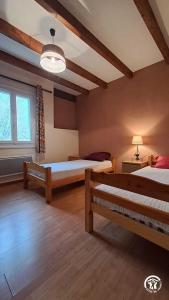 een slaapkamer met twee bedden en een raam bij L'esquirou in Lagarrigue