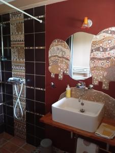 une salle de bains avec un lavabo et un miroir dans l'établissement La Sirène Endormie, à Penmarcʼh