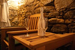 a table with two wine glasses and a bottle on it at Apartmány Kunčice in Staré Město
