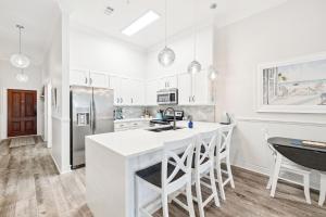 a kitchen with white cabinets and a large white island at The Magnolia by 30A Escapes in Rosemary Beach +18 photos