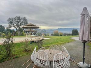 ein Tisch mit Stühlen und einem Sonnenschirm auf einer Straße in der Unterkunft Domaine des Étoiles - Gîtes in Gillonnay