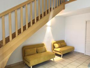 ein Zimmer mit zwei Stühlen und einer Treppe in der Unterkunft Domaine des Étoiles - Gîtes in Gillonnay