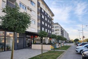 un edificio su una strada con auto parcheggiate in un parcheggio di Sajam Nest Apartment a Novi Sad
