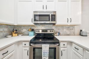 a kitchen with a stove and a microwave at The Magnolia by 30A Escapes in Rosemary Beach
