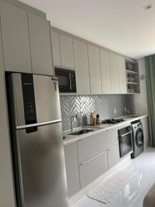 een keuken met een roestvrijstalen koelkast en apparatuur bij Ap completo in Balneário Camboriú