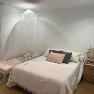 een witte kamer met een bed met kussens erop bij ideal apartamento a pie de playa in Torremolinos