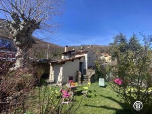 een klein huisje in een tuin met roze stoelen bij Le moulin in Sahorre