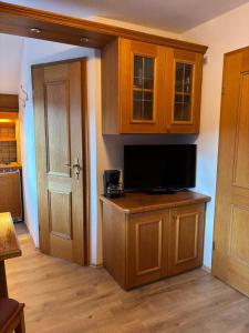 een keuken met houten kasten en een tv op een aanrecht bij Apartment Kranzberg in Mittenwald