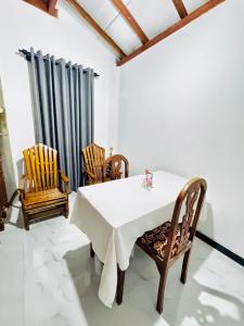 a dining room with a white table and chairs at Villa Nevya in Weligama