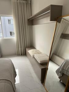 een kleine slaapkamer met een spiegel en een bed bij Ap completo in Balneário Camboriú +4 foto's