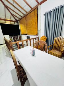 a dining room with a white table and chairs at Villa Nevya in Weligama