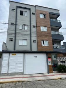 een gebouw met drie garagedeuren ervoor bij Ap completo in Balneário Camboriú