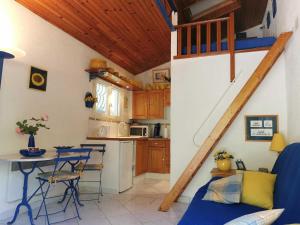 une cuisine avec un escalier, une table et des chaises dans l'établissement Les lauriers, à Sahorre