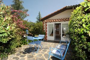 un patio avec des chaises et une table devant une maison dans l'établissement Les lauriers, à Sahorre