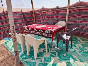 a table and chairs in a tent on the beach at ESCAPE cAMp2 in Bidiyah