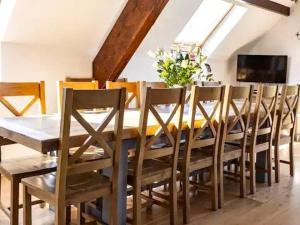 een eetkamer met een tafel met stoelen en een televisie bij Bedw Barn in Newtown
