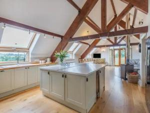 een grote keuken met witte kasten en een groot eiland bij Bedw Barn in Newtown