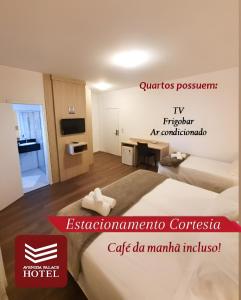 een hotelkamer met 2 bedden en een bord voor een hotel bij Avenida Palace Hotel in Joinville