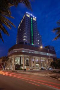 un edificio con una señal verde encima en Acacia Hotel Manila en Manila