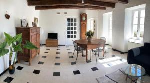 een woonkamer met een tafel, stoelen en een klok bij Chez denise in Paulinet