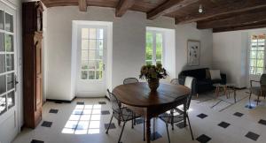 een woonkamer met een houten tafel en stoelen bij Chez denise in Paulinet