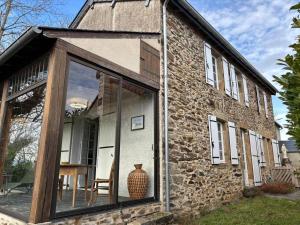 een uitbouw aan een stenen huis met een groot raam bij Chez denise in Paulinet