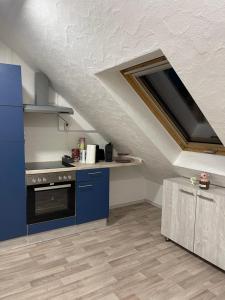 een keuken met blauwe kasten en een fornuis bij Casa da Peppe Schöne Auszeit im Schwarzwald in Calw