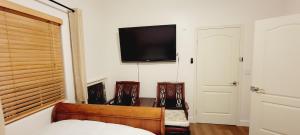 - une chambre avec 2 chaises et une télévision murale dans l'établissement Welcoming & Spacious 2-Bedroom Guest Suite in Torrance 20 Minutes from LAX, à Torrance