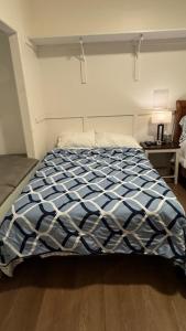 - un lit avec une couette bleue et blanche dans une chambre dans l'établissement Welcoming & Spacious 2-Bedroom Guest Suite in Torrance 20 Minutes from LAX, à Torrance