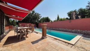 een terras met een tafel en stoelen naast een zwembad bij Cristian Case Vacanza in Colonna