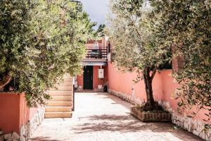 een steegje met bomen voor een gebouw bij Cristian Case Vacanza in Colonna