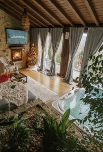 un salon avec un sapin de Noël et un bain à remous dans l'établissement Casa Favo de Mel - Jacuzzi Privado & Lareira - Piscina, à Arcos de Valdevez
