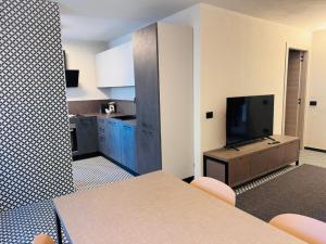 een keuken met een tafel en een tv in een kamer bij Central Guest in Sauze dʼOulx