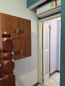 a room with wooden lockers and a door to a room at Canto da Praia Suítes in Arraial do Cabo