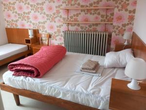 a bed with a red pillow on it in a bedroom at Trivalou in Fauch