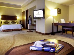 a hotel room with a bed and a flat screen tv at Grand Mercure Beijing Central in Beijing +98 photos